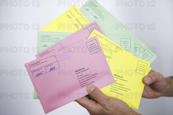A man holds postal voting documents for the European elections, district council elections and