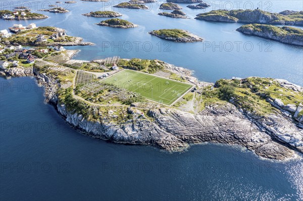 Aerial view over football stadium on rocky island, fishing village Henningsvaer, Lofoten, Norway,