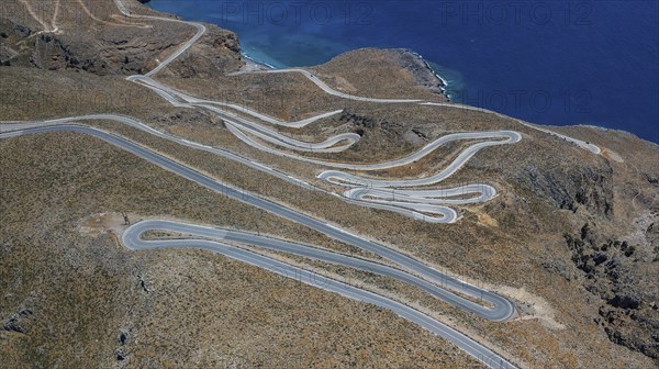 Aerial view of pass road serpentines from to Passo Anopoli above south coast of Crete right Libyan