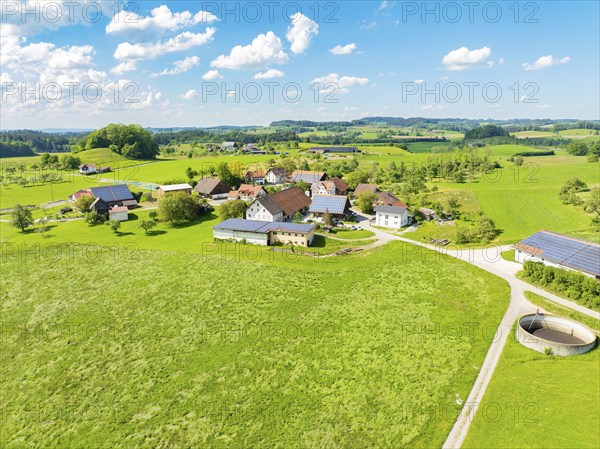Aerial view of an extensive meadow landscape with a village and farms, glass fibre installation,