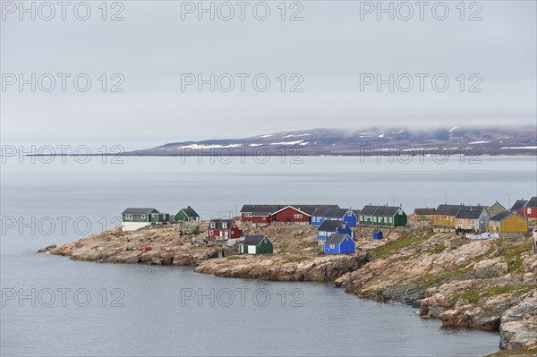 Colourful houses on a rocky coastal landscape, remote Arctic Inuit settlement Ittoqqortoormiit,
