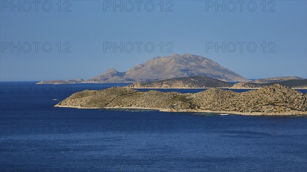 Close to a larger island in the blue sea, surrounded by blue sky and natural landscape, Makri