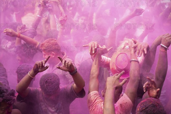 Revellers dancing in the beat of music as they celebrate Holi on a street, the Hindu spring
