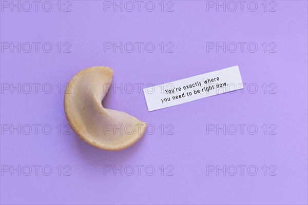 Fortune cookie with motivational text on paper saying 'You're exactly where you need to be right