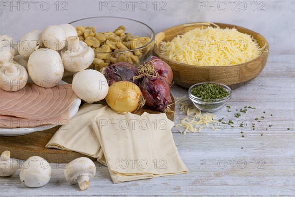 Various ingredients for cooking, including mushrooms, cheese, onion and ham on a table