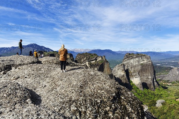 Group of tourists on rocks, enjoying the view, Meteora Trail, blue sky, Thessaly, Greece, Europe