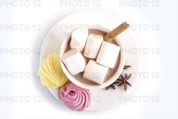 A cup of hot chocolate with marshmallow, meringue and spices isolated on white. closeup. top view