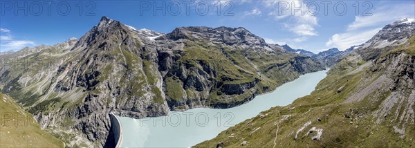 Aerial panoramic view over am of lake Mauvoisin, artificial channels in the rock fill the lake,
