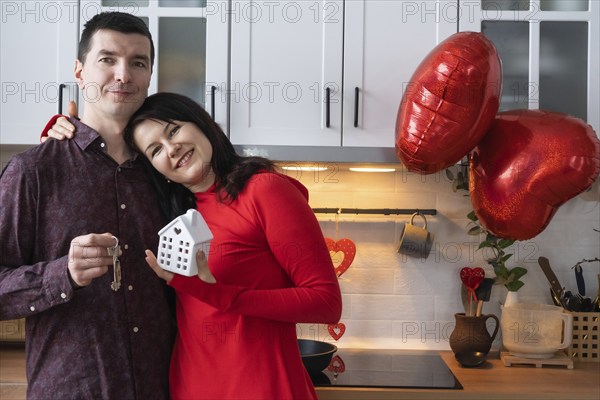 Man and woman in love date at home in kitchen with keys of house. Valentine's Day, happy couple,