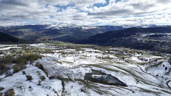 Aerial view of snow-covered fields and distant mountains under a cloudy sky. Posof, Ardahan, TURKEY
