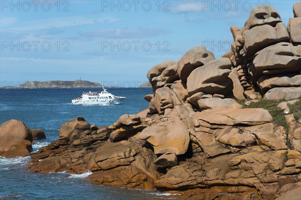 Rocky coast with passing boat and small island on the horizon, Ploumanac'h, Ploumanach,