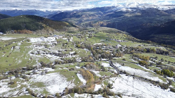 Aerial view of snow-patched fields surrounded by mountains and clouds. Posof, Ardahan, TURKEY