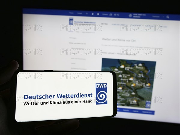 Stuttgart, Germany, 06-06-2024: Person holding smartphone with logo of German meteorological