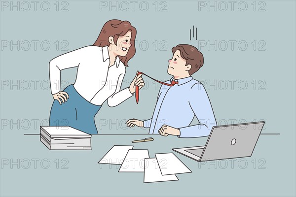 Young woman employee pull male employee tie seduce him at workplace. Female worker show attraction