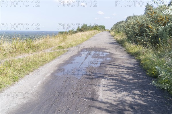 Wide gravel path on a hill with a distant view