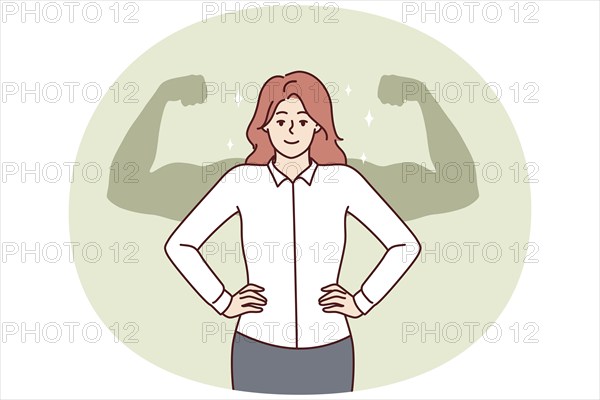 Successful businesswoman stands with hands on waist imagining giant muscular arms behind back.
