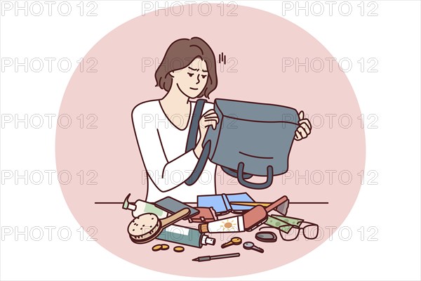 Puzzled woman shakes out contents of bag on table trying to find wallet with money or mobile phone.