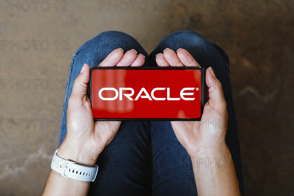 In this photo illustration, the Oracle Corporation logo is displayed on a smartphone screen