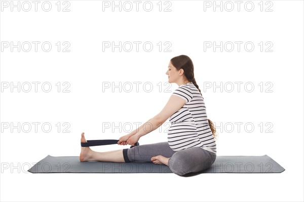 Pregnancy yoga exercise, pregnant woman doing yoga asana Janu Sirsasana A Head-to-Knee Forward Bend