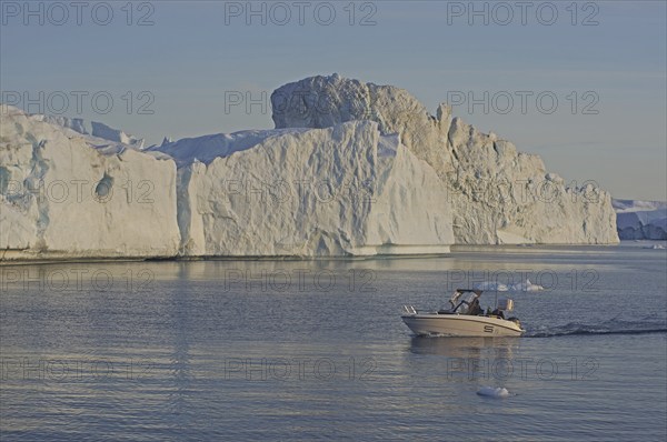 Small boat in front of icebergs, midnight sun, Ilulissat, Disko Bay, Denmark, Greenland, North