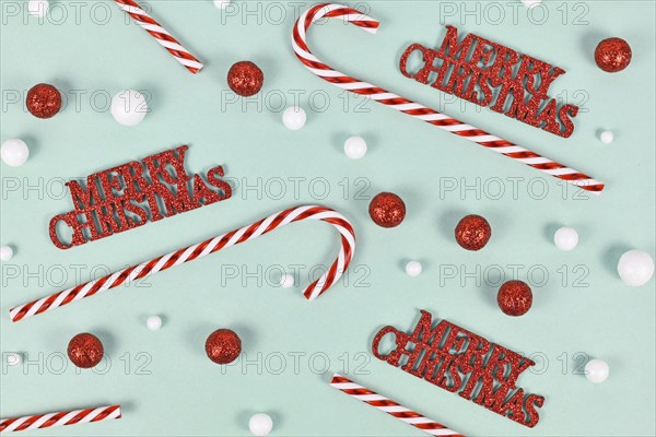 Christmas ornaments with 'Merry Christmas' text, candy canes and snowballs on mint green background