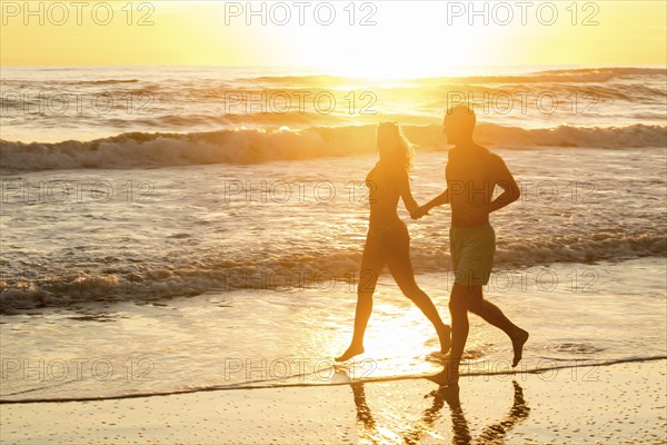 Couple at sunset at Playa Santa Teresa, Santa Teresa, Peninsula de Nicoya, Guanacaste, Costa Rica,