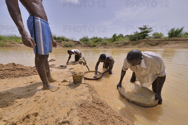 Diamond hunters searching for diamonds in a mine with sieves and shovels, near Koidu, Koidu-Sefadu,
