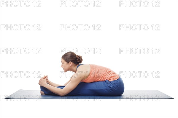 Sporty fit woman doing Ashtanga Vinyasa yoga back bending asana Paschimottanasana, seated forward