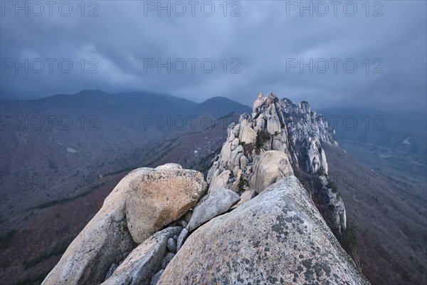 View of stones and rock formations from Ulsanbawi rock peak in stormy weather with clouds.