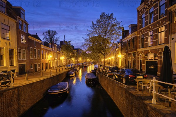 Typical Netherlands view, canal with boats and houses illuminated in the evening. Haarlem,