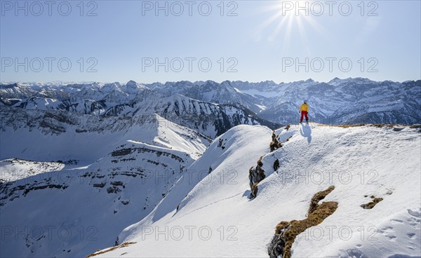 Ski tourers at the summit of Schafreuter, view of snowy mountain panorama, Karwendel, Tyrol,