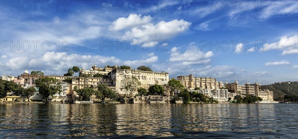 India luxury tourism concept background, panorama of Udaipur City Palace from Lake Pichola.