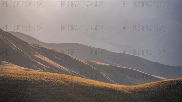 Mountain landscape detail in the evening light, Hills overgrown with yellow grass, Toktogul