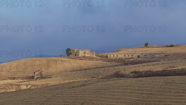 Dry hilly landscape, fields, farmstead, building, blue cloudy sky, Madonie National Park, autumn,