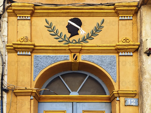 Colourful house entrance, decorated front door, black head with white headband, traditional symbol