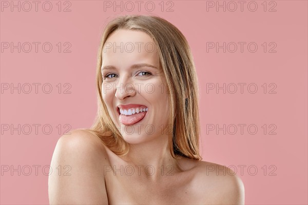 Funny girl is looking straight forward and showing her tongue