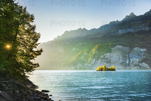 Last light over Lake Walen with the small chive island in the turquoise water and mountain range