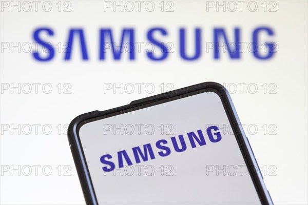 Samsung logo of the TV and smartphone manufacturer on a mobile phone and screen