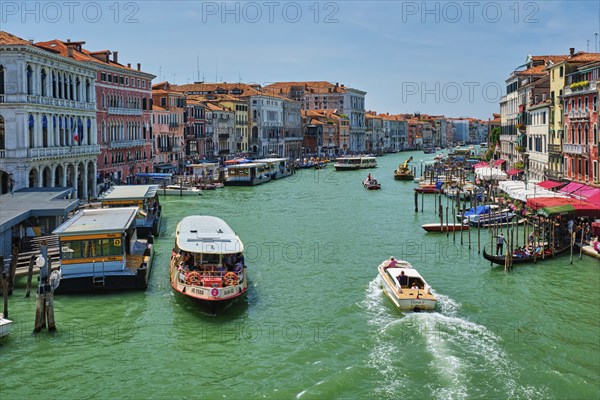 VENICE, ITALY, JULY 19, 2019: Grand Canal with boats, vaporetto and gondolas on sunset from Rialto
