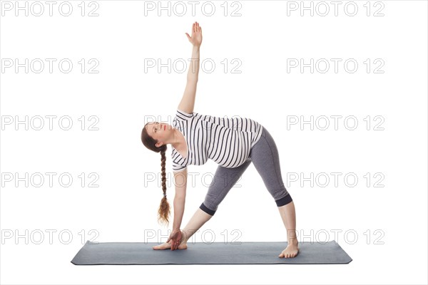 Pregnancy yoga exercise, pregnant woman doing asana Utthita trikonasana, extended triangle pose
