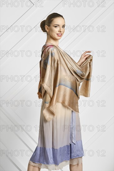 Cheerful woman with silk scarf posing in profile