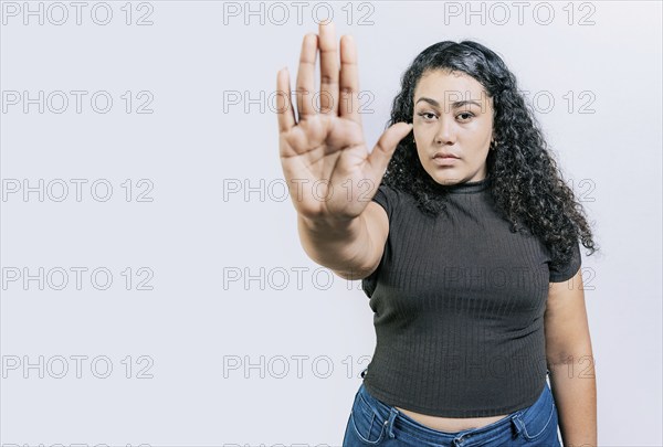 Serious woman rejecting with the palm of hand isolated. People gesturing stop isolated. Latin woman