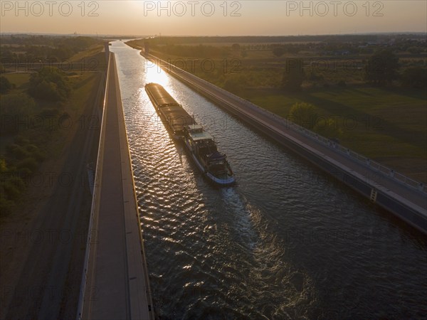 Drone shot, cargo ship in the sunset on the Mittelland Canal, Magdeburg waterway junction, canal