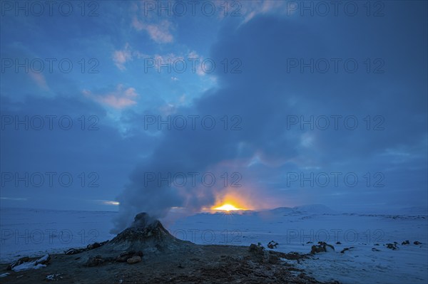 Mud pot with steam source at sunrise, Hverir solfataras field, fumaroles, snow-covered geothermal