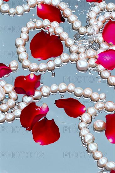 Pearl necklace in the water with splashes, drops and reflections, AI generated