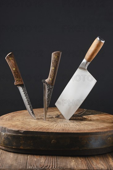 Cleaver and two meat knives sticking out of wooden stump