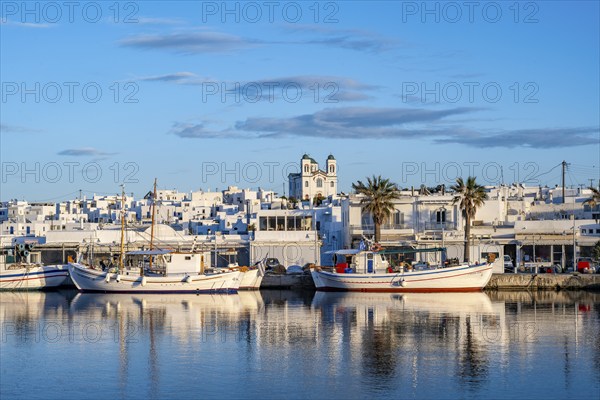 View of Naoussa, Fishing boats in the harbour at sunset, reflected in the sea, White Cycladic