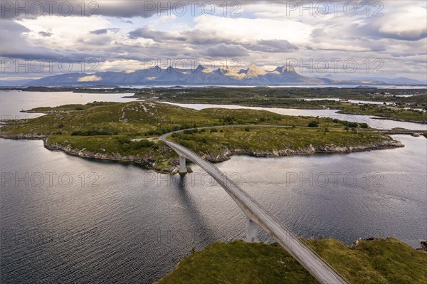 Road with bridge over Inse, behind the mountain range Seven Sisters, Herøy island, Helgeland coast,