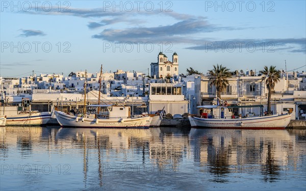 View of Naoussa, Fishing boats in the harbour at sunset, reflected in the sea, White Cycladic