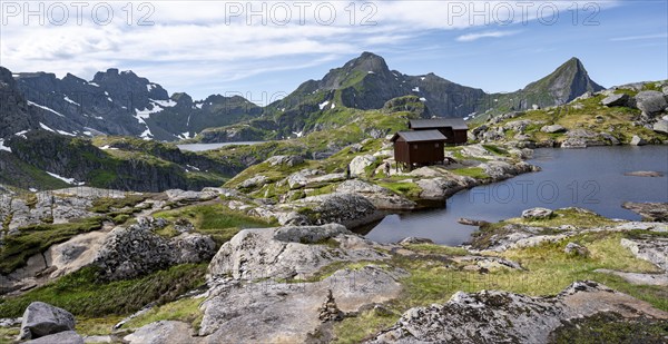 Mountain hut Munkebu hut by a small lake, mountain landscape with rocky peaks and lakes,